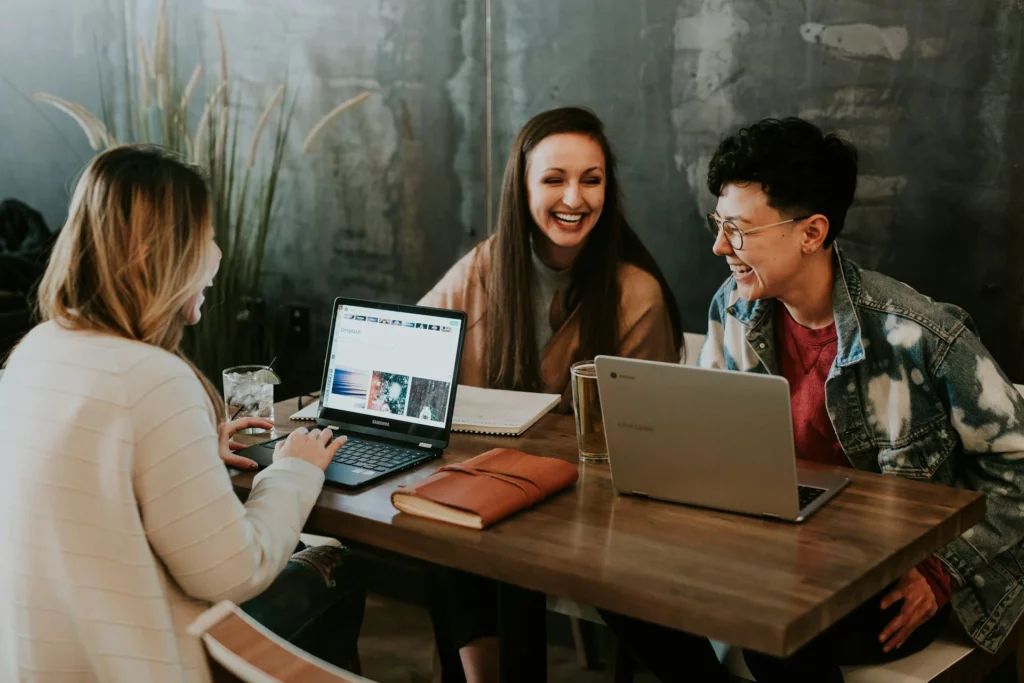 Mujeres reunidas en una mesa con sus portátiles